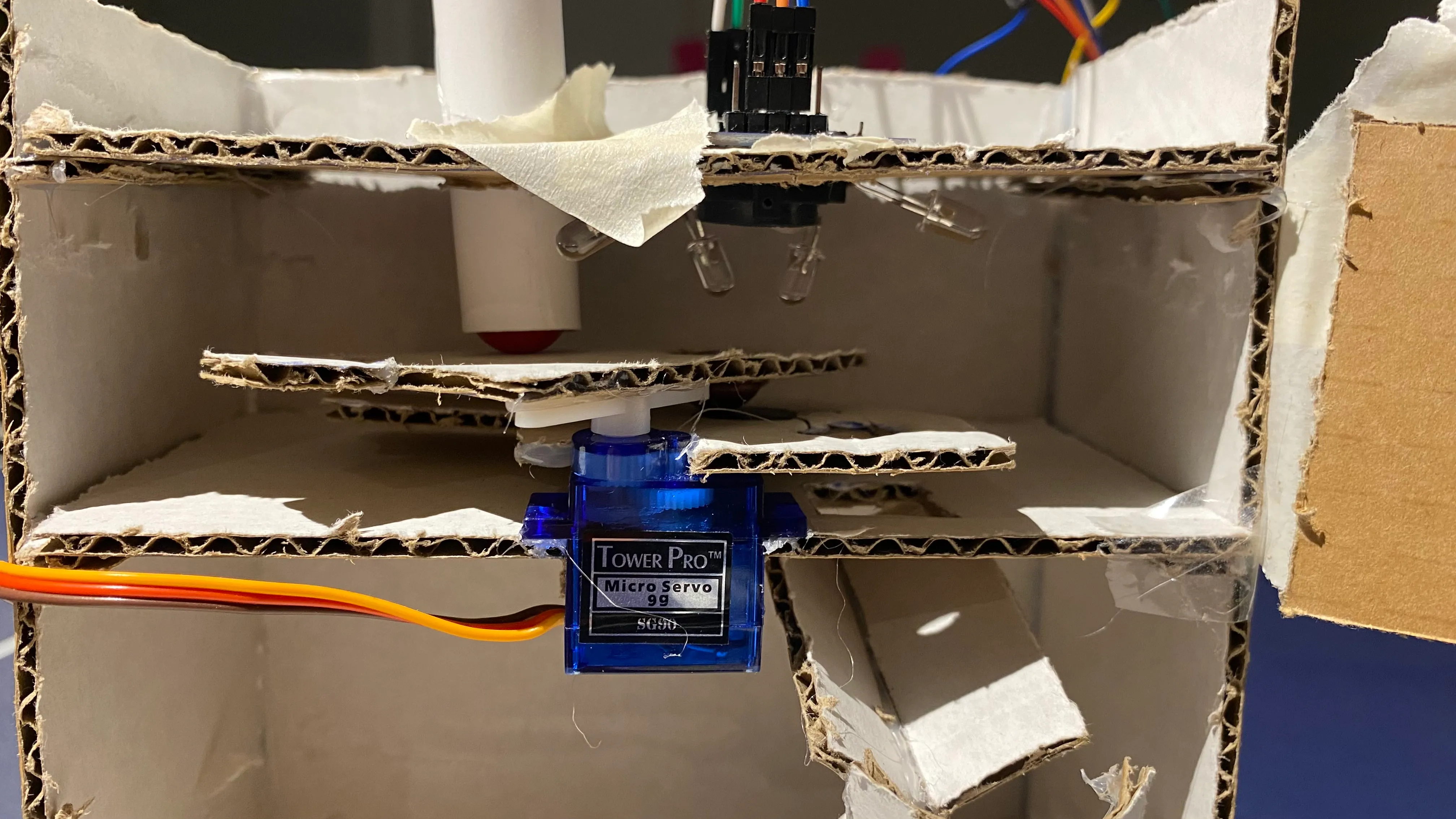 Revealed Servo mechanism. Cardboard door isolates the lighting condition for the sensor, achieving more consistent results required for defininig color ranges.
